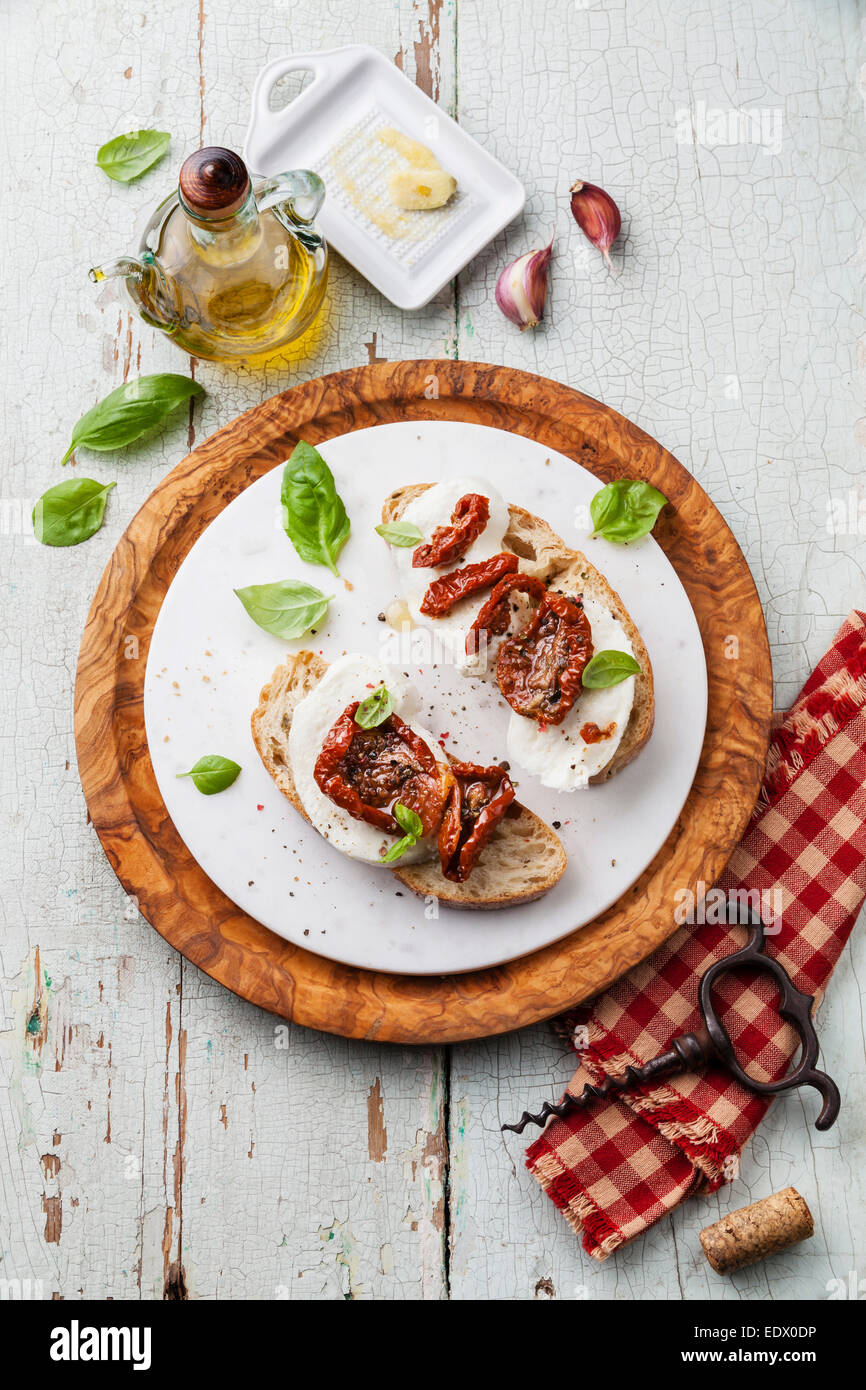 Ciabatta pain avec de la Mozzarella et tomates séchées au soleil bleu sur fond de bois Banque D'Images