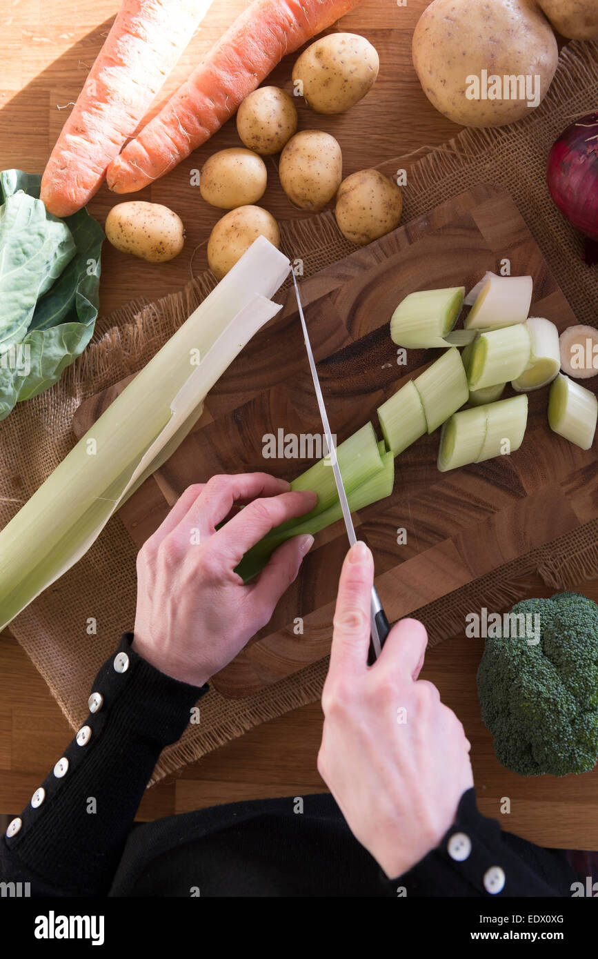 A womans mains émincer les légumes pour une recette. Banque D'Images