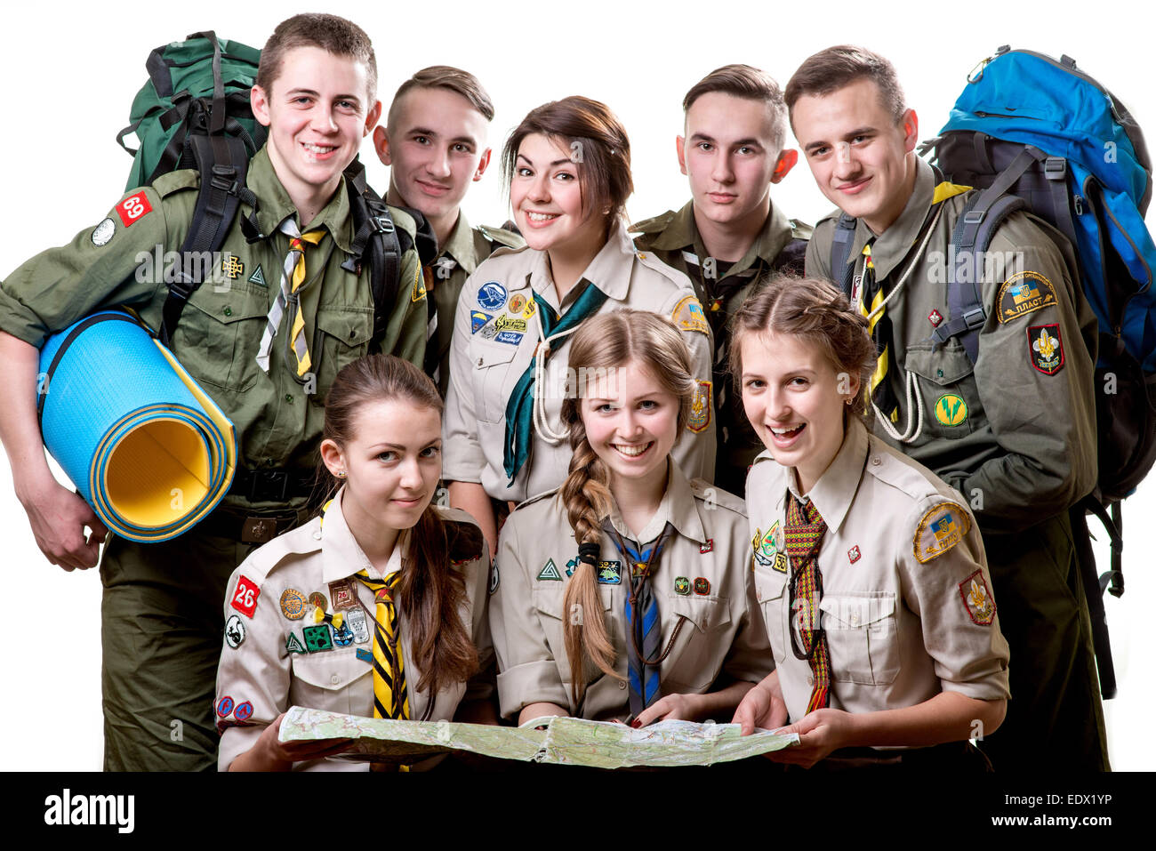 Friendly jeunes scouts en uniforme englobant ensemble isolé sur fond blanc Banque D'Images