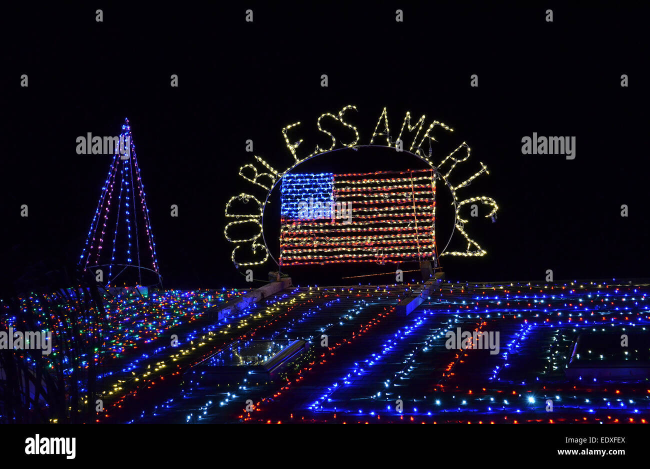 Une maison en Floride, USA, est décoré à Noël avec des chaînes de lumières colorées formant un drapeau des États-Unis et "Dieu bénisse l'Amérique." Banque D'Images