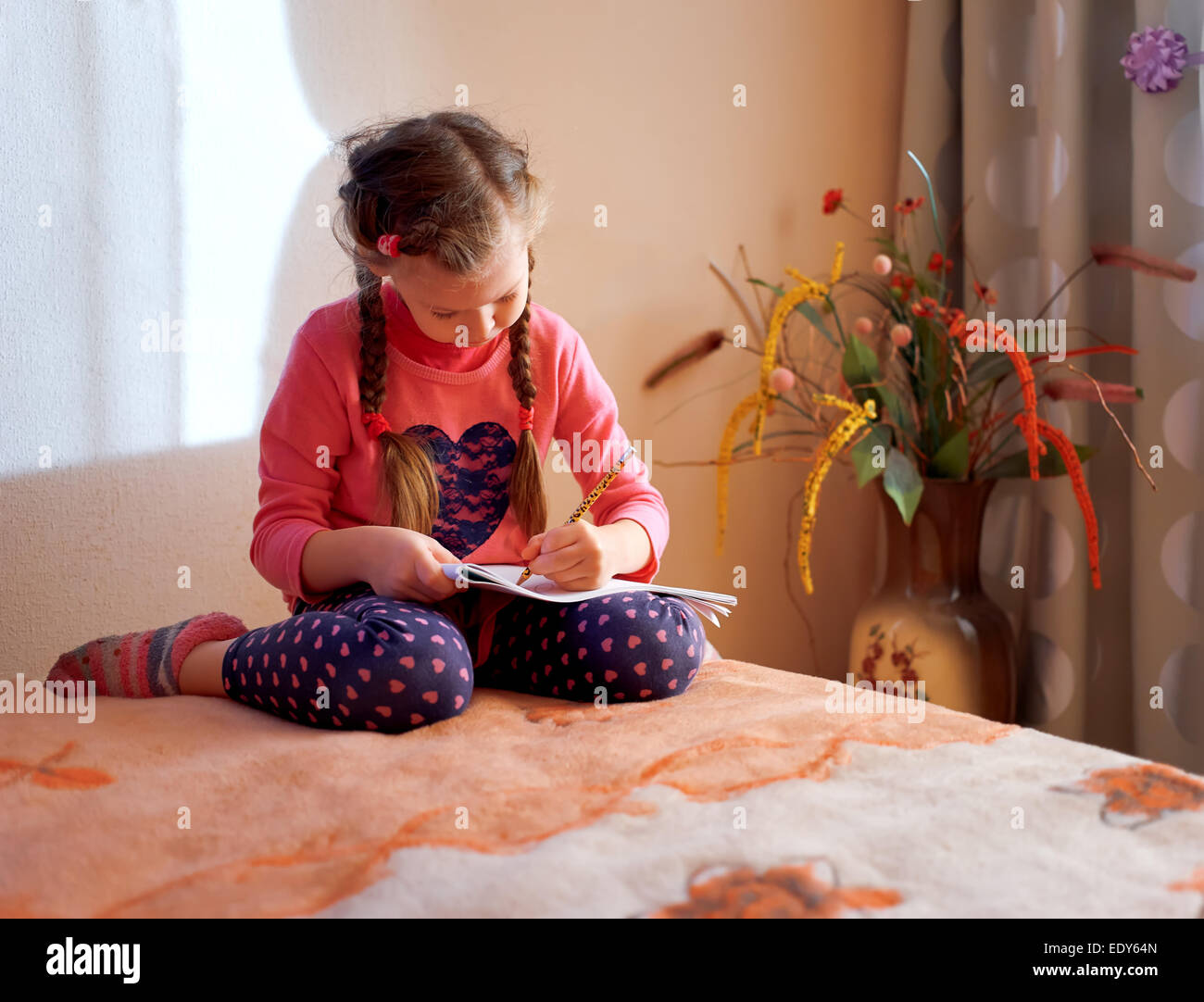 Jeune fille est à l'aide de dessin crayons de couleur tout en jetant sur marbre Banque D'Images
