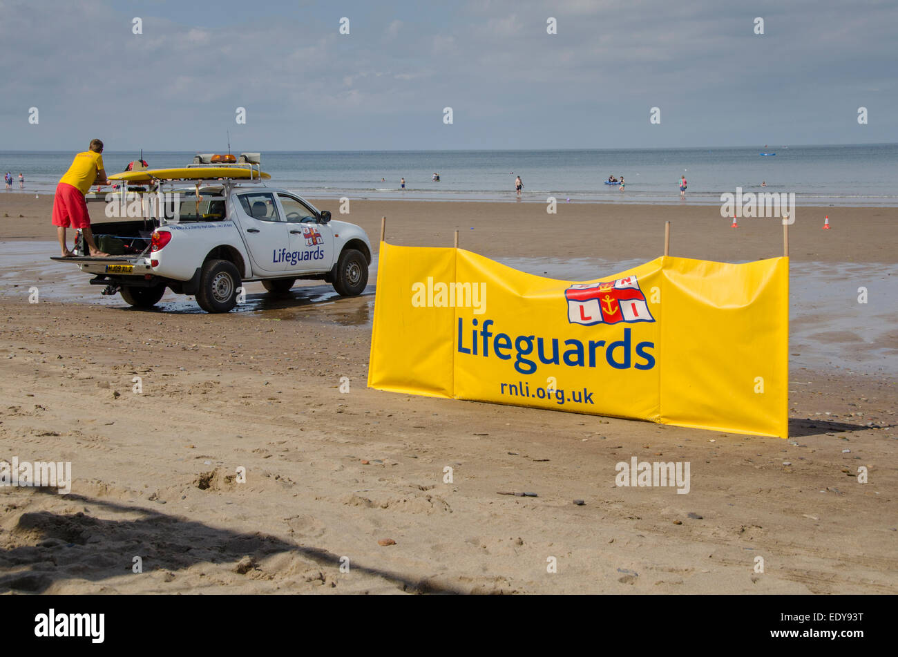 Jeune homme de devoir, en tant que sauveteur RNLI est à regarder les gens de mer et debout sur l'arrière du camion en stationnement - Whitby, North Yorkshire, Angleterre, Royaume-Uni. Banque D'Images