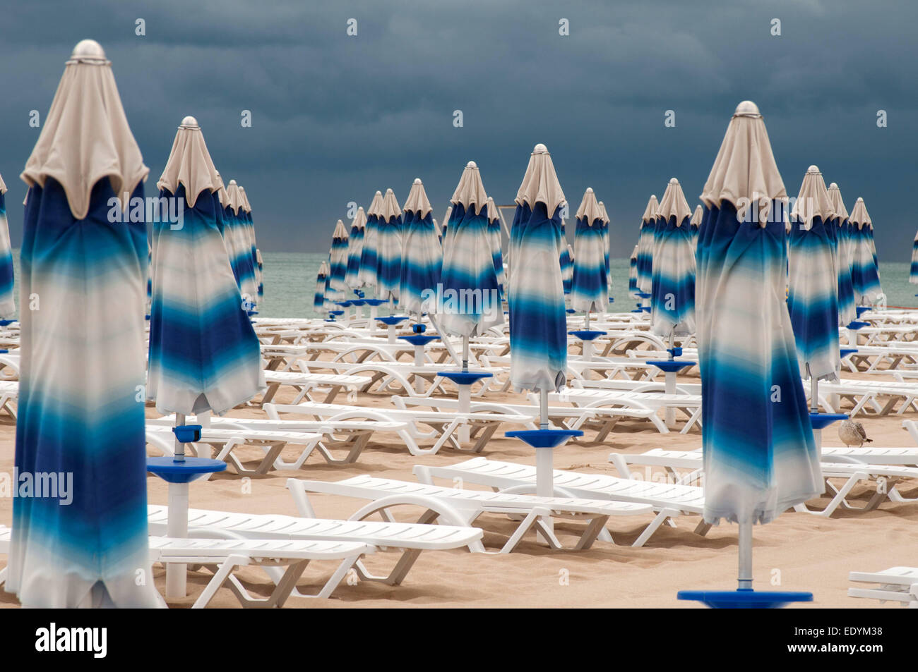 C'est l'arrière-plan sur la plage. Des parasols a été fermé, de gros nuages s'accrochaient à la mer. Banque D'Images