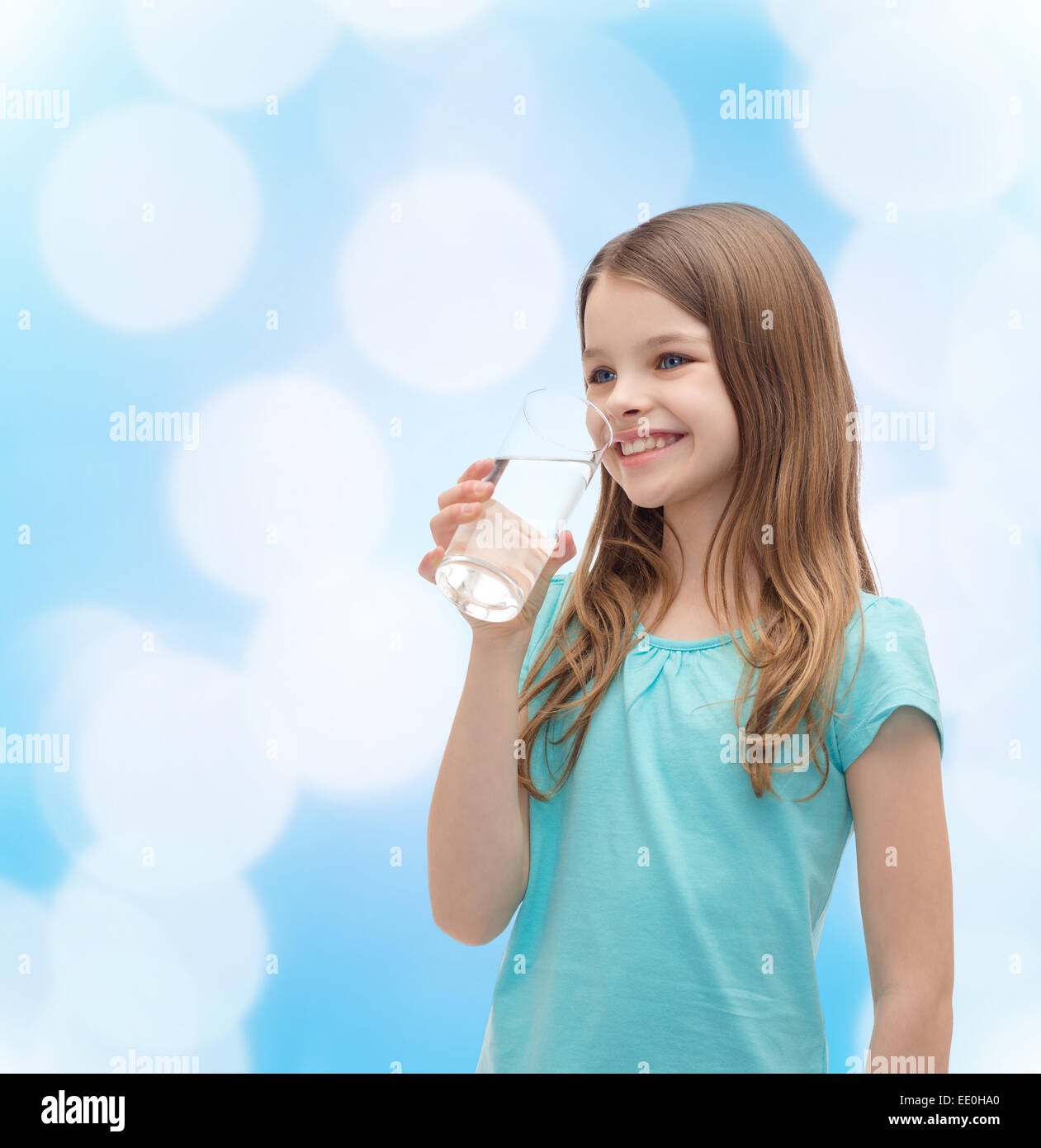 Smiling little girl avec verre de l'eau Banque D'Images