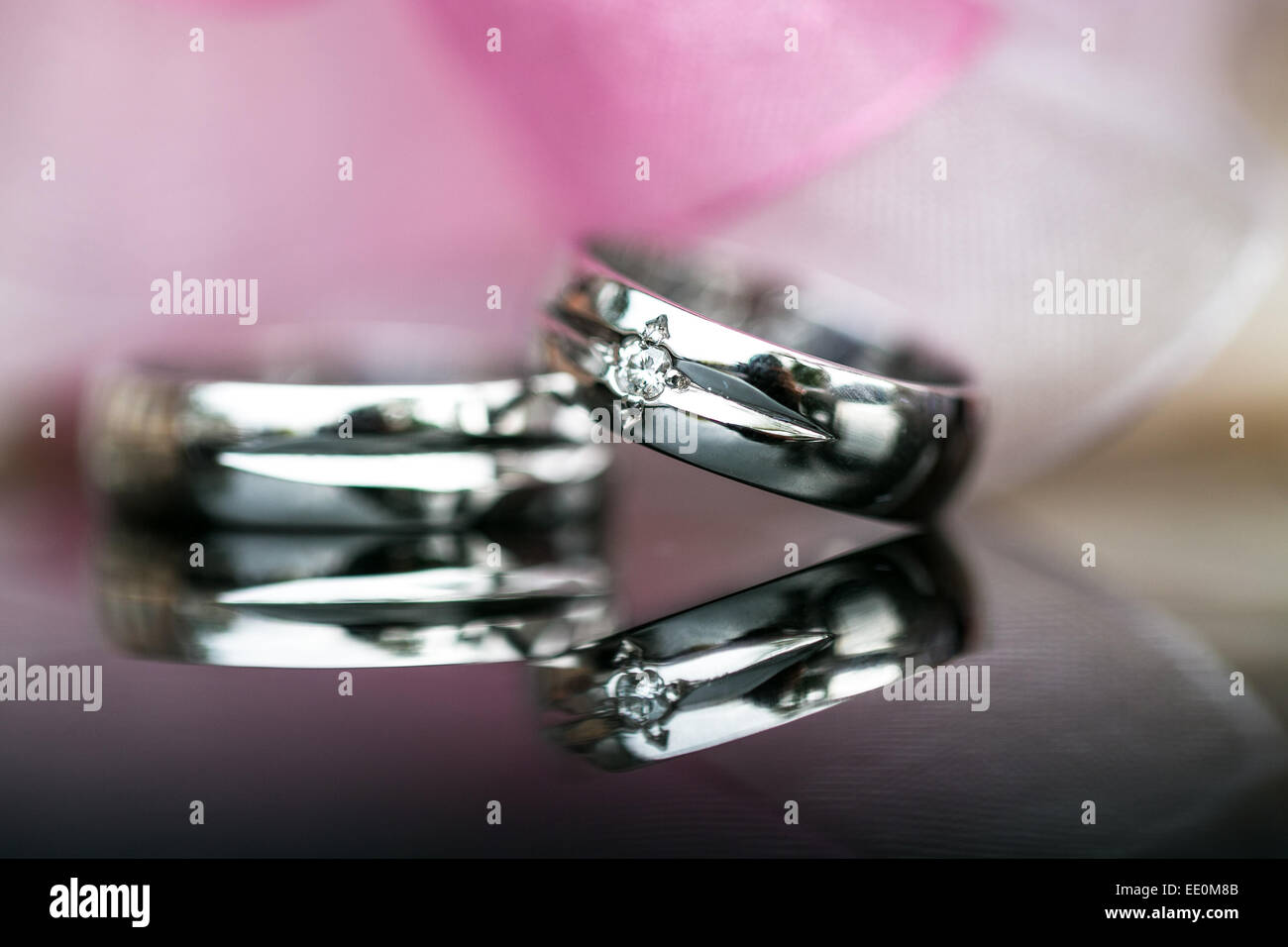Deux magnifiques bagues de mariage sur un jour de mariage, tourné sur une surface réfléchissante. Concept d'amour. Banque D'Images