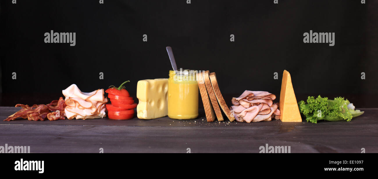 Un Club Sandwich déconstruite composée de jambon, dinde, bacon, laitue, tomate, fromage et d'une vinaigrette à la moutarde au miel. Banque D'Images