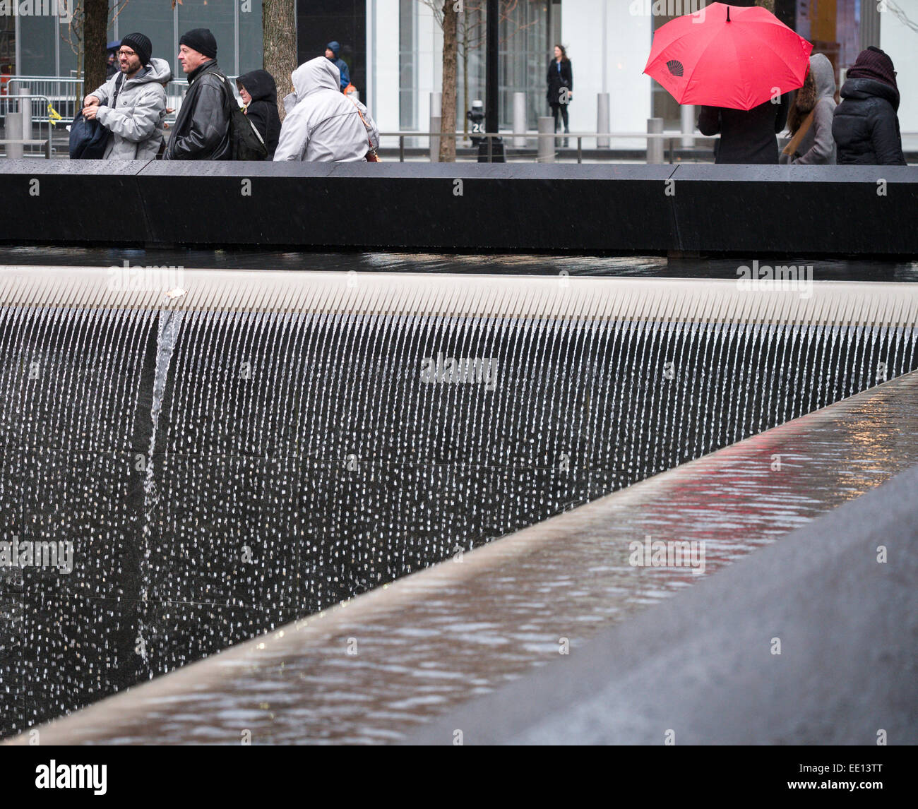 Falls Memorial détail dans la pluie avec parapluie rouge. Détail de la cascade qui compose une partie clé le 9/11 memorial. Banque D'Images