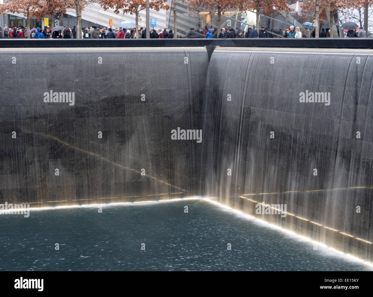 Réflexions à la memorial du 11 septembre à Ground Zero. Les touristes entourent la fosse profonde de la chute d'eau Banque D'Images