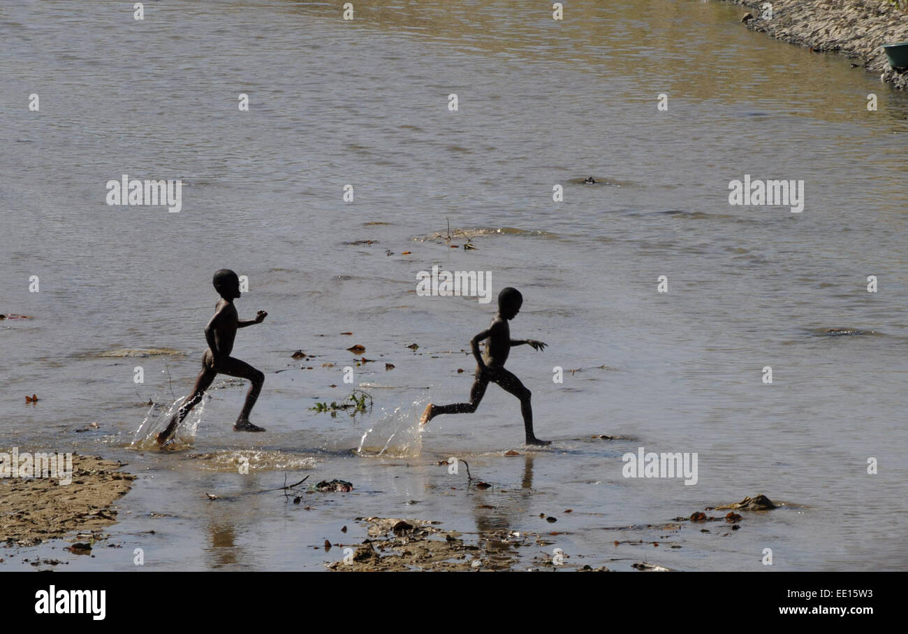 Ouanaminthe, Haïti. 12 Jan, 2015. Les garçons haïtiens jouent dans la rivière dans la ville de Ouanaminthe Masacre, Haïti, le 12 janvier, 2015. Un séisme de magnitude 7,3 a frappé Haïti le 12 janvier 2010, tuant au moins 222 570 personnes. Les villes les plus touchées sont Port-au-Prince et Léogâne et Jacmel dans le sud et le sud-ouest du pays. © Onelio Dominguez/Xinhua/Alamy Live News Banque D'Images