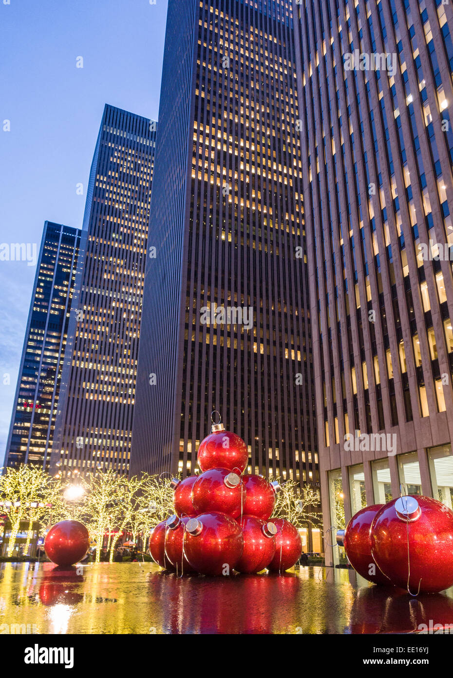 Boules de Noël géant rouge ci-dessous les tours. Voir la soirée de Noël Boules énormes placées dans le miroir d'eau et fou Banque D'Images