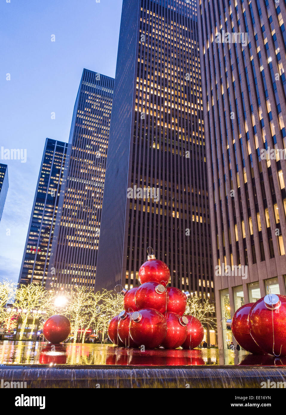 Boules de Noël géant rouge ci-dessous les tours. Voir la soirée de Noël Boules énormes placées dans le miroir d'eau et fou Banque D'Images
