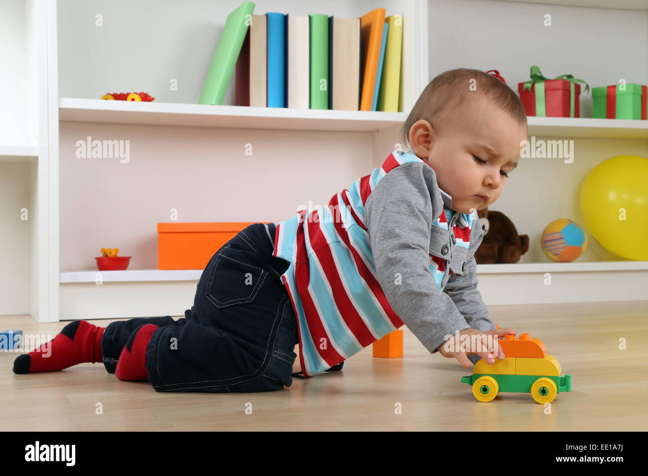 Portrait d'un bébé jouant avec location de jouet dans la chambre des enfants Banque D'Images