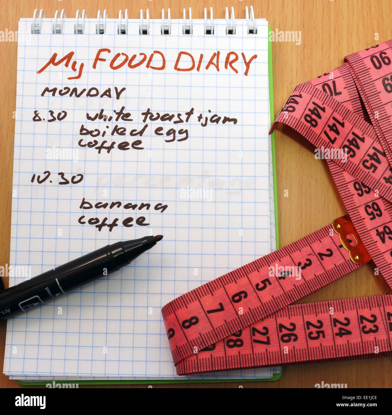 Ruban à mesurer, un marqueur et un bloc-notes avec un journal alimentaire Banque D'Images