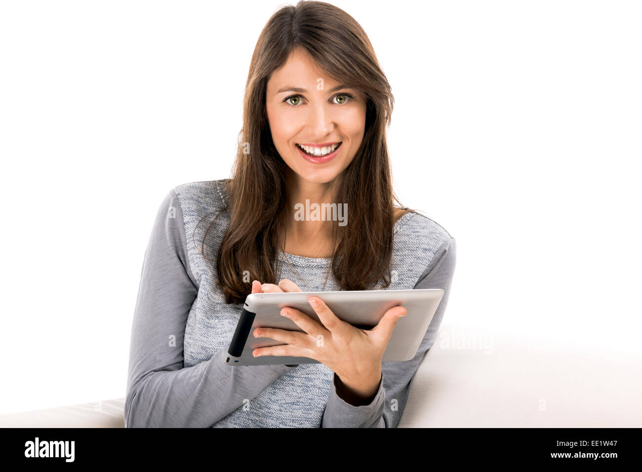 Belle femme assise sur le sofa et travailler avec une tablette Banque D'Images