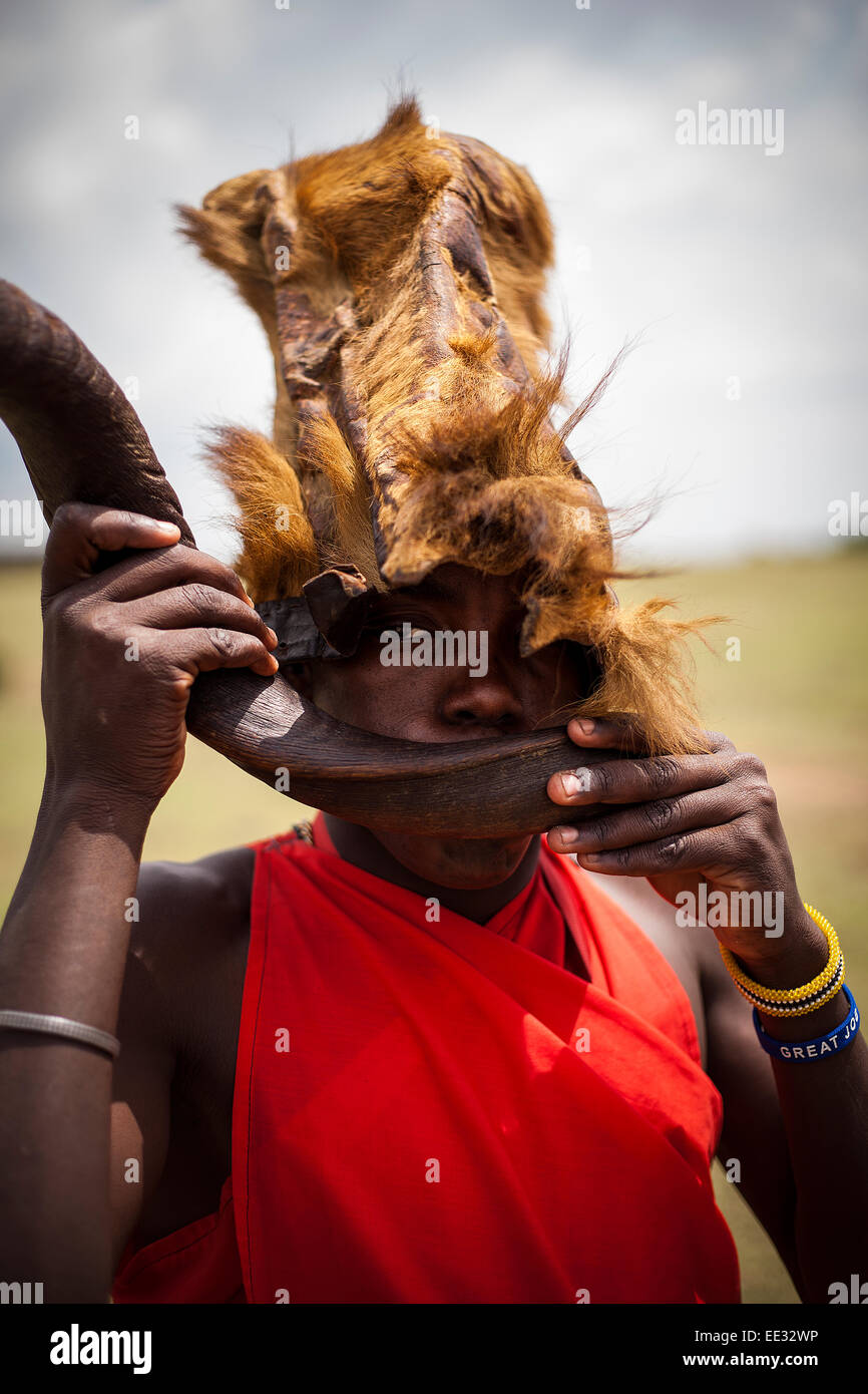 Guerrier Masai portant chapeau fait de peau de lion dans le Masai Mara, Kenya Banque D'Images