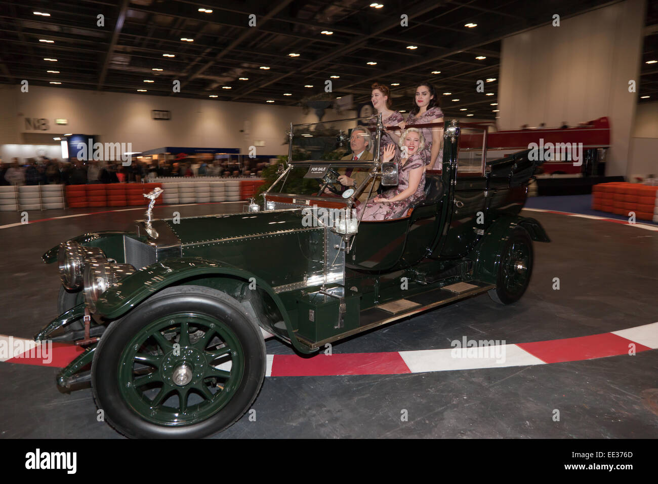 Un groupe de chant, école de fille un Vintage Rolls Royce Silver Ghost dans le Grand Avenue, au London Classic Car Show. Banque D'Images