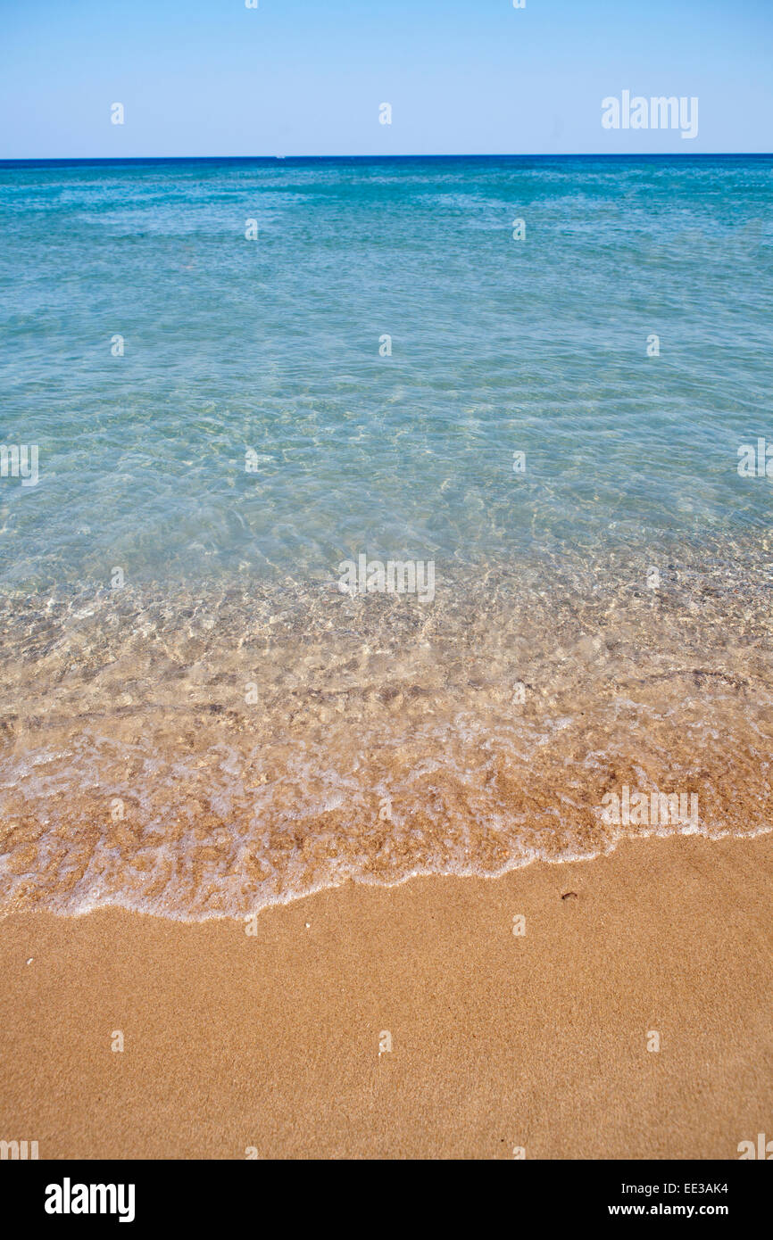La plage de Tsambika, l'île de Rhodes, Grèce. Bord de l'eau claire Banque D'Images