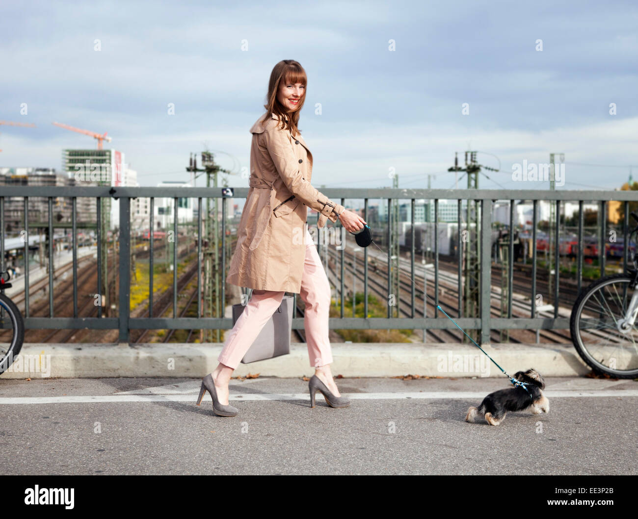 Jeune femme de promener le chien sur un pont, Munich, Bavière, Allemagne Banque D'Images