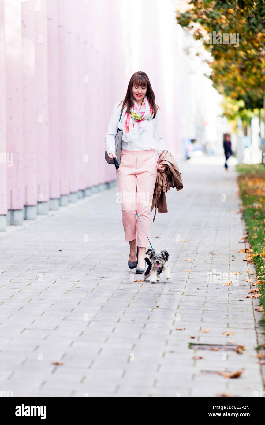Young woman walking the dog outdoors, Munich, Bavière, Allemagne Banque D'Images