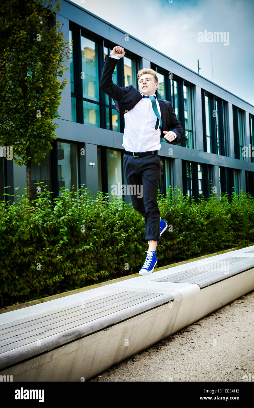 Young businessman saute dans l'air, Munich, Bavière, Allemagne Banque D'Images