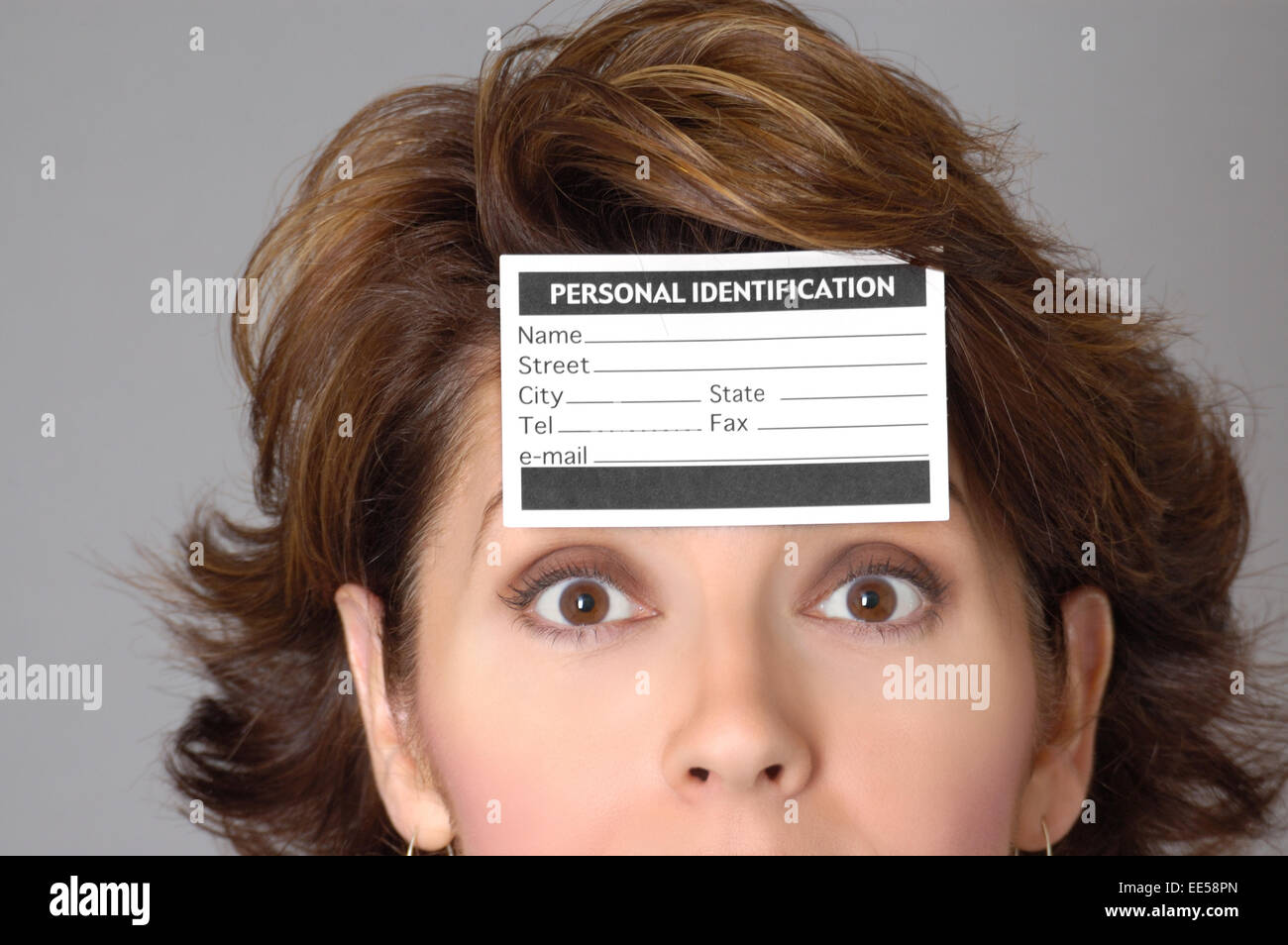 Femme portant une carte d'identification sur son front. Peut représenter les questions de confidentialité, le vol d'identité, de la citoyenneté ou d'autres questions Banque D'Images