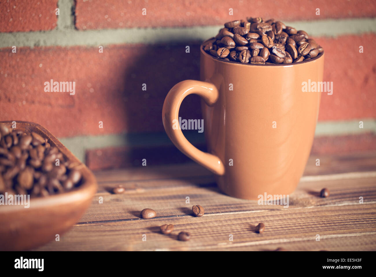 Grains de café dans une tasse avant de brick wall Banque D'Images