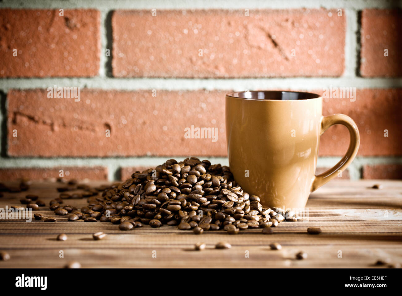 Les grains de café sur la table avant de brick wall Banque D'Images