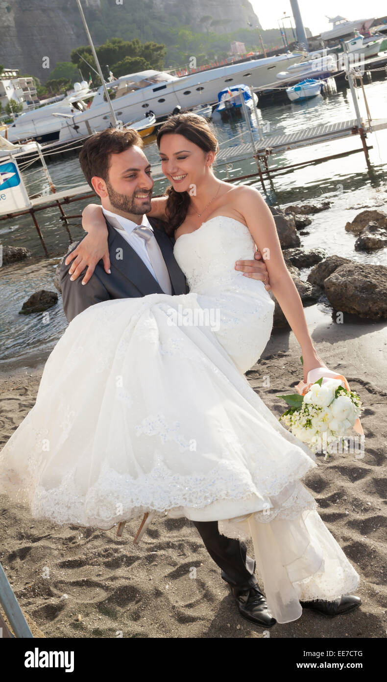 Couple marié de jour de leur mariage. Mariée dans les bras de son mari. Banque D'Images