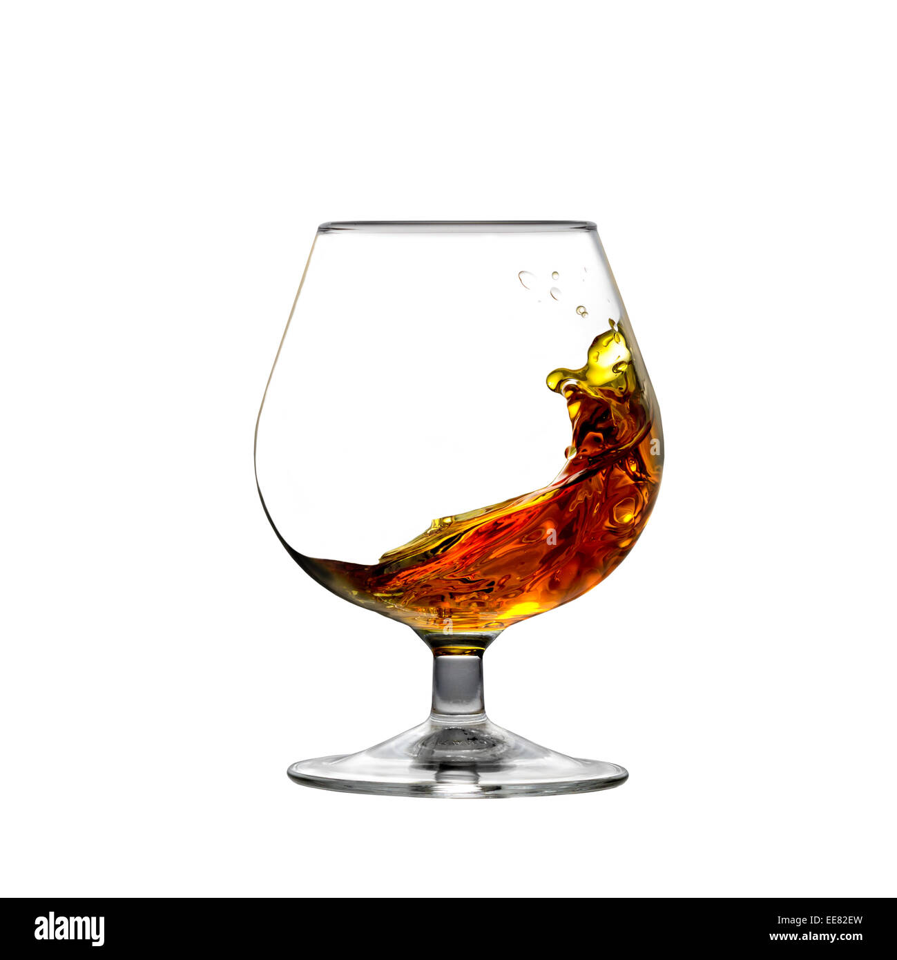 Square shot de cognac se déplaçant à l'intérieur un verre isolé sur fond blanc Banque D'Images