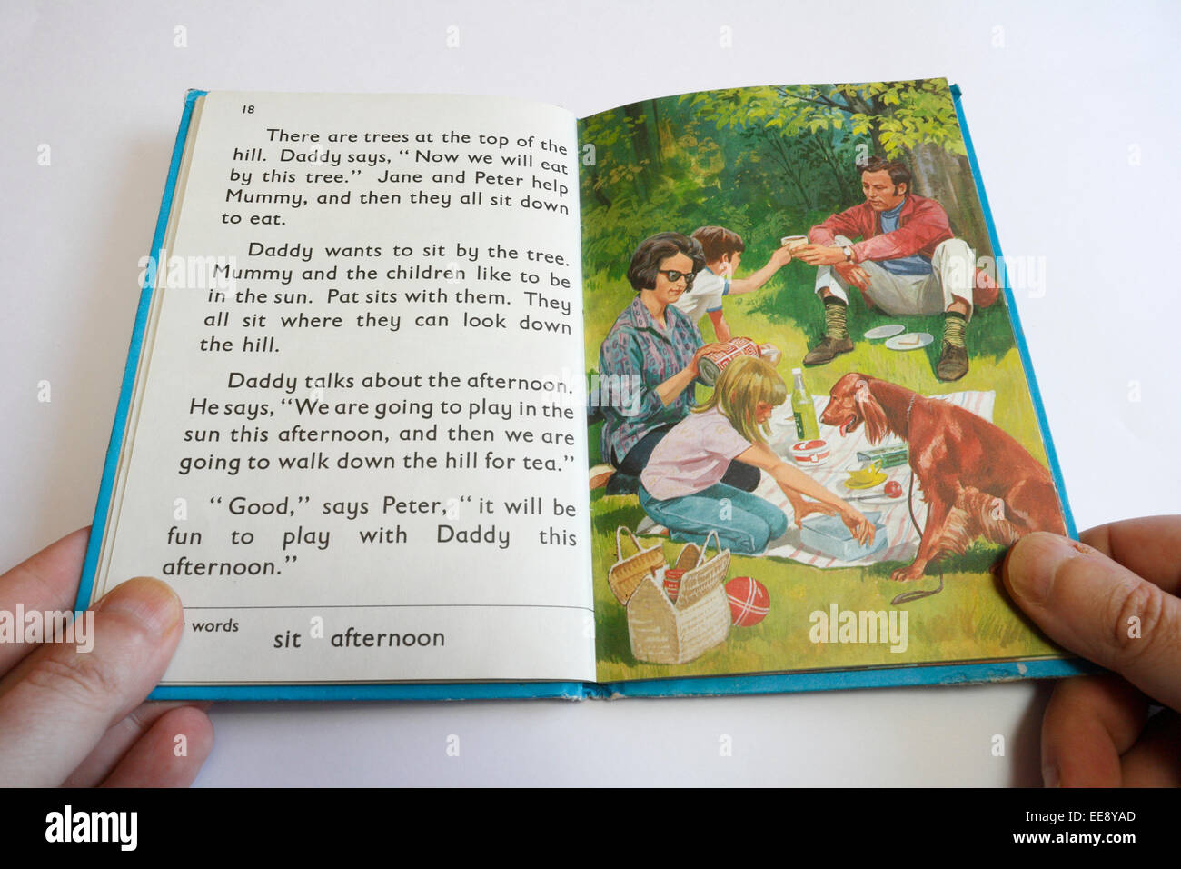 Personne tenant un livre de lecture pour enfants de Ladybird, apprenant à lire Banque D'Images