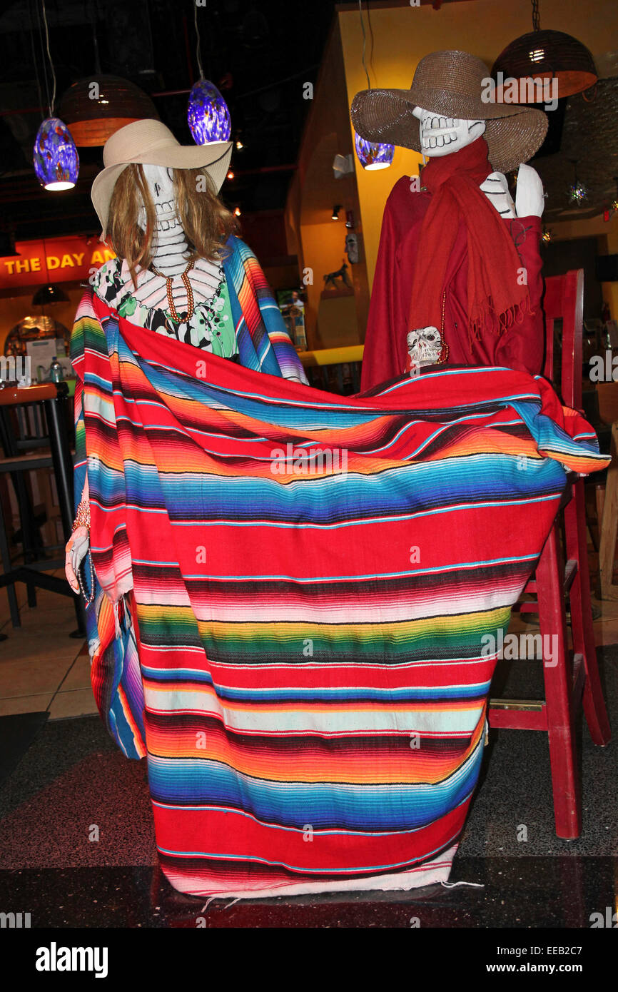 Célébration de squelettes Dia De Los Muertos enveloppé dans une couverture à rayures colorées dans un bar Tequila, de l'aéroport de Miami Banque D'Images