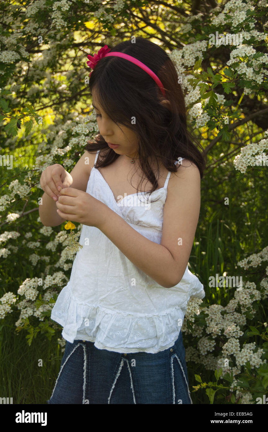 Une fillette de 7 ans faire une chaîne des fleurs, Reading, Berkshire, Royaume-Uni Banque D'Images