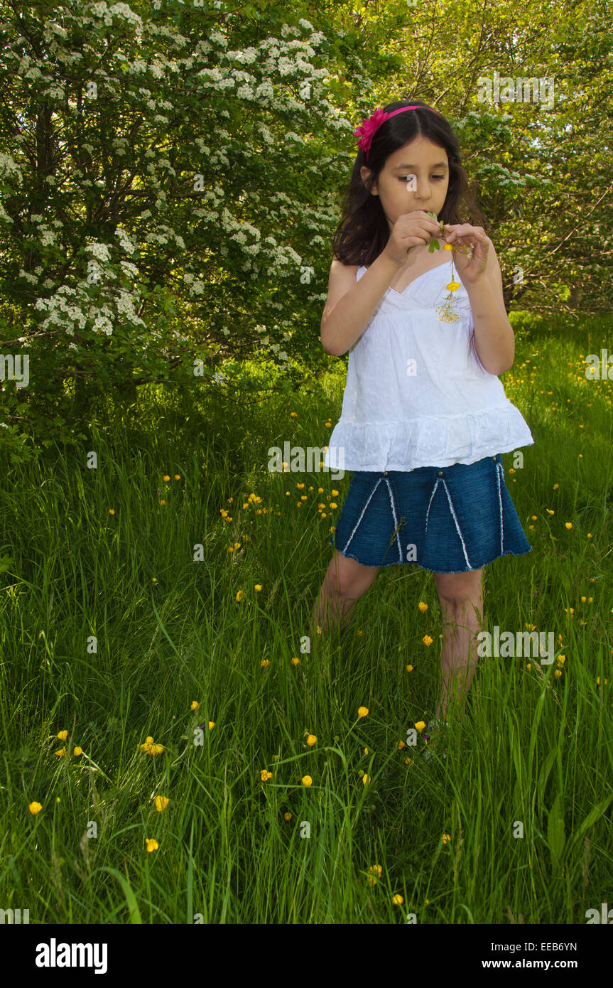 Une fillette de 7 ans faire une chaîne des fleurs, Reading, Berkshire, Royaume-Uni Banque D'Images