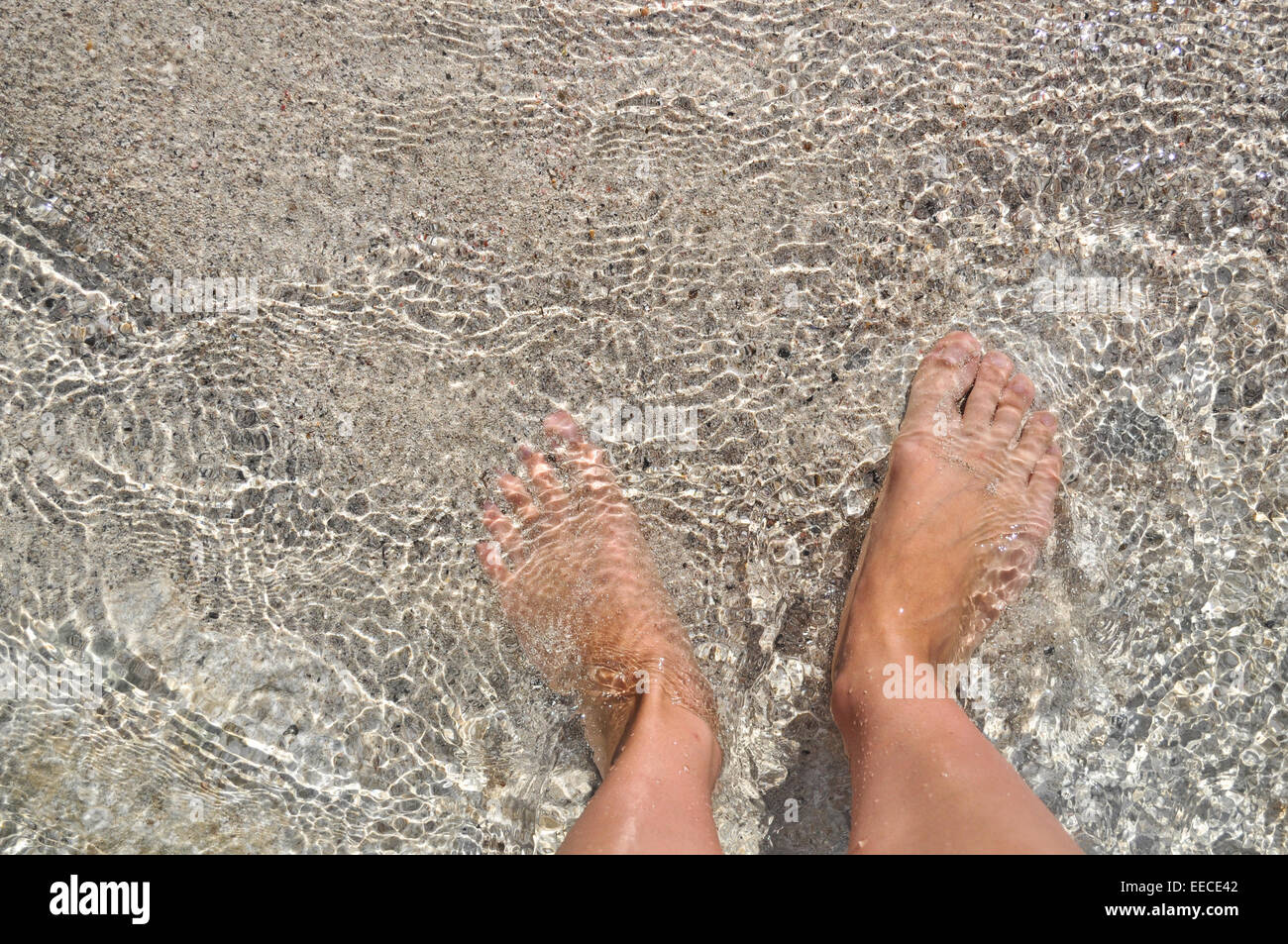 Les pieds dans l'eau sur le sable. La mer Méditerranée, l'île de Crète. La Grèce. Banque D'Images