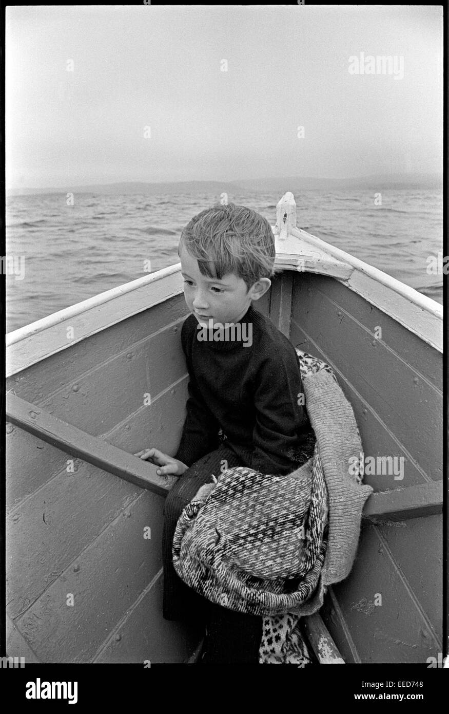 Garçon en bateau, près de Scalloway sur façon de pique-nique du dimanche. Banque D'Images