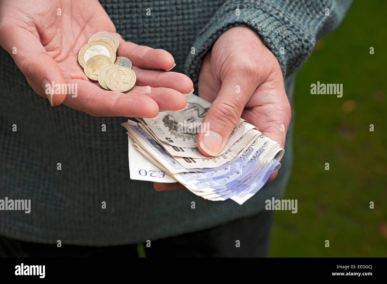 Gros plan de l'homme personne détenant des billets de banque anglais billets de banque et pièces d'argent comptant concept d'affaires de financement d'épargne Angleterre Royaume-Uni Banque D'Images