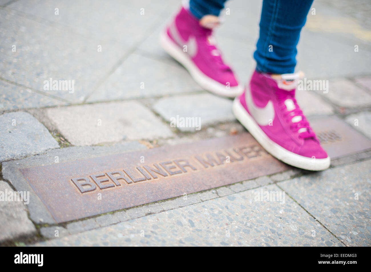 Berlin, Allemagne, les piétons s'exécute sur une plaque commémorative pour l'histoire de mur Banque D'Images