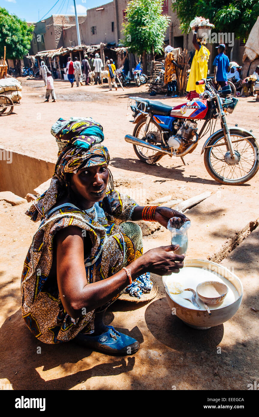 Femme peul vente du lait dans les rues de Djenné, au Mali. Banque D'Images