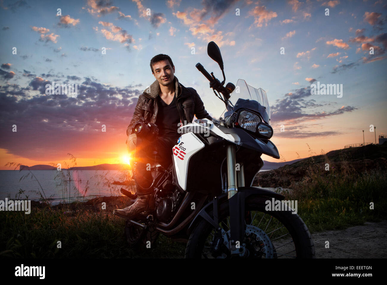 Portrait d'un jeune homme sur une moto Banque D'Images