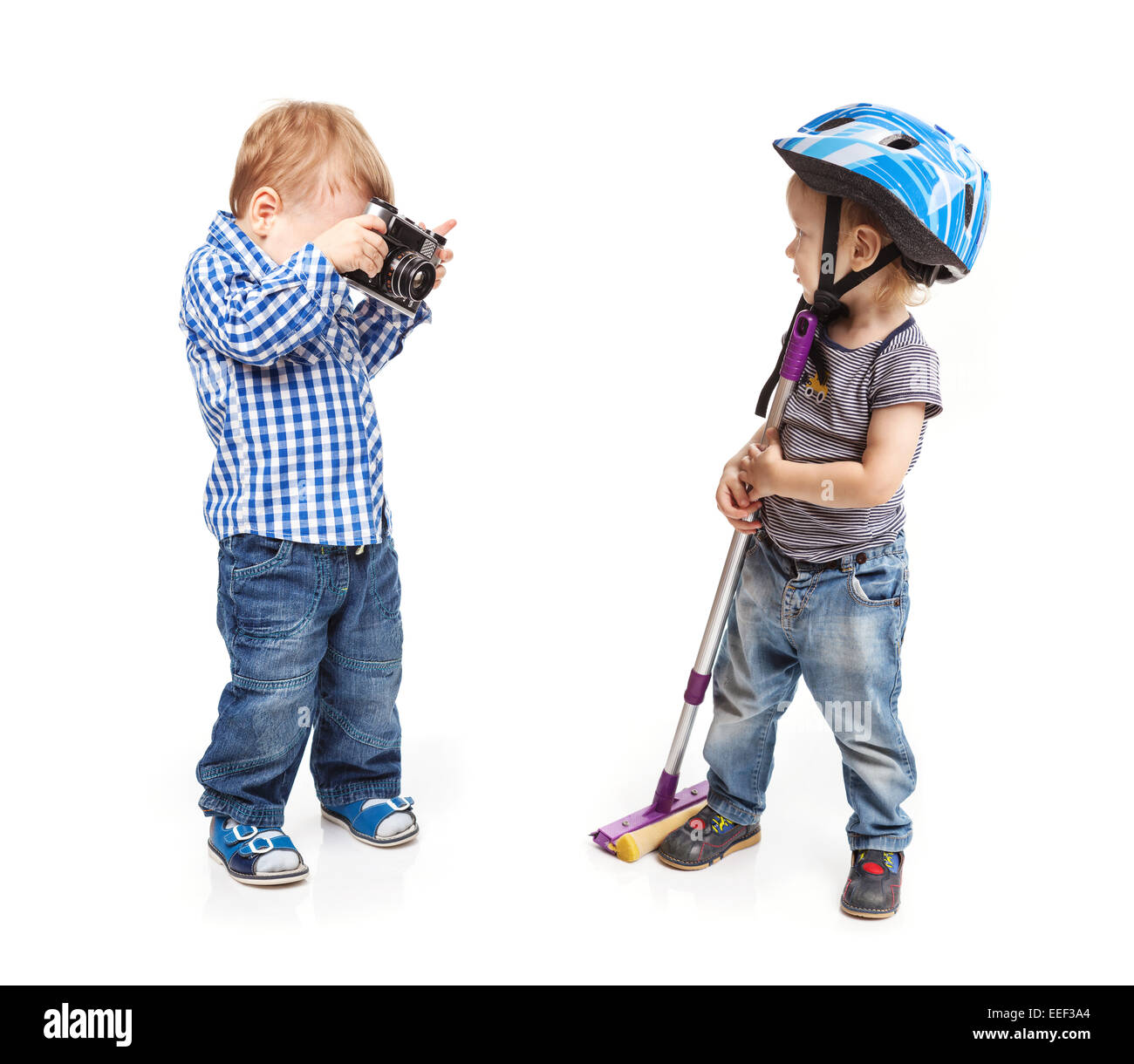 Deux jeunes garçons jouent au tout-petits : un garçon tenant une caméra de posing with a mop Banque D'Images