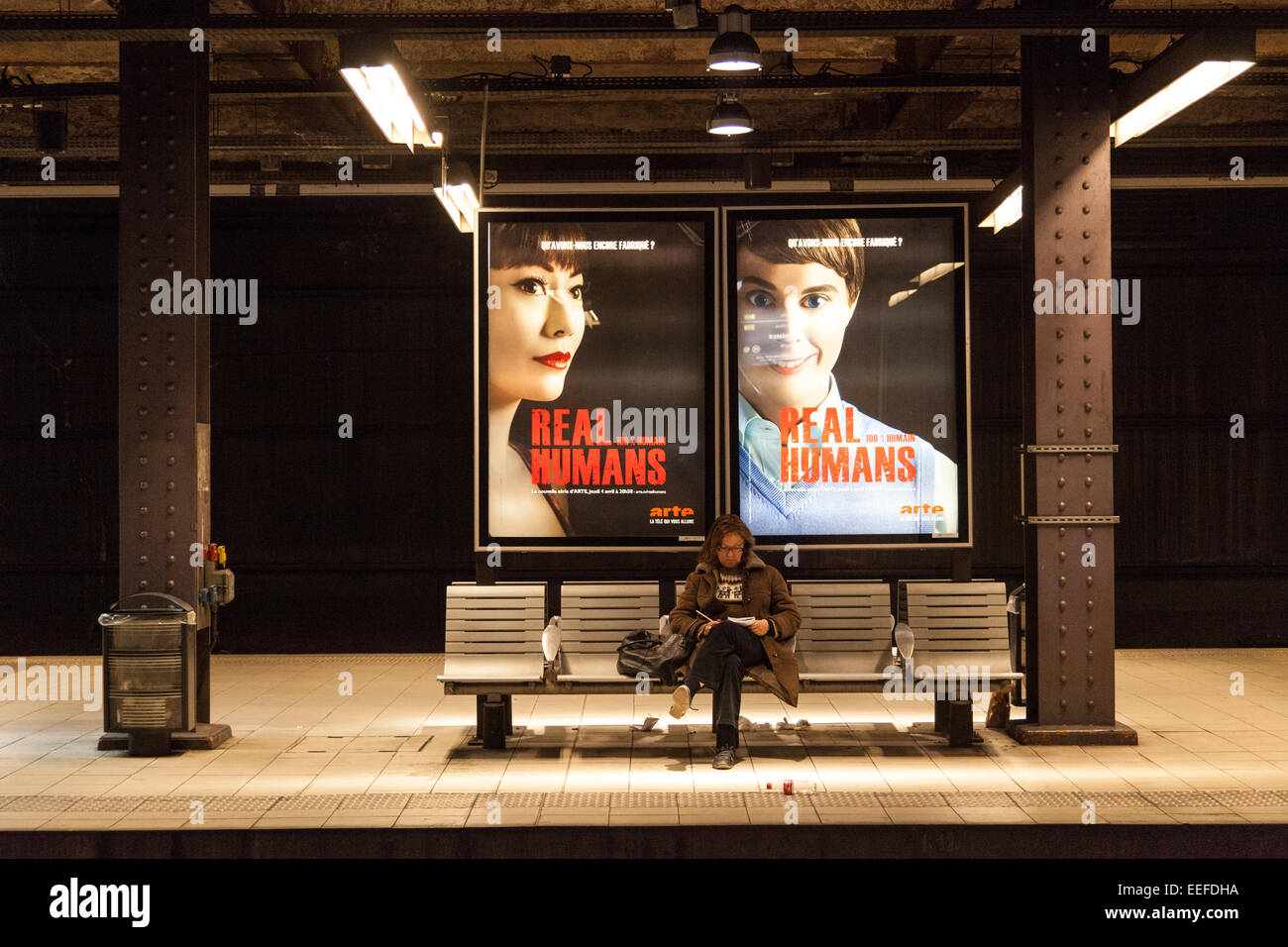 Homme assis sur un banc dans une station de métro de Paris, France Banque D'Images