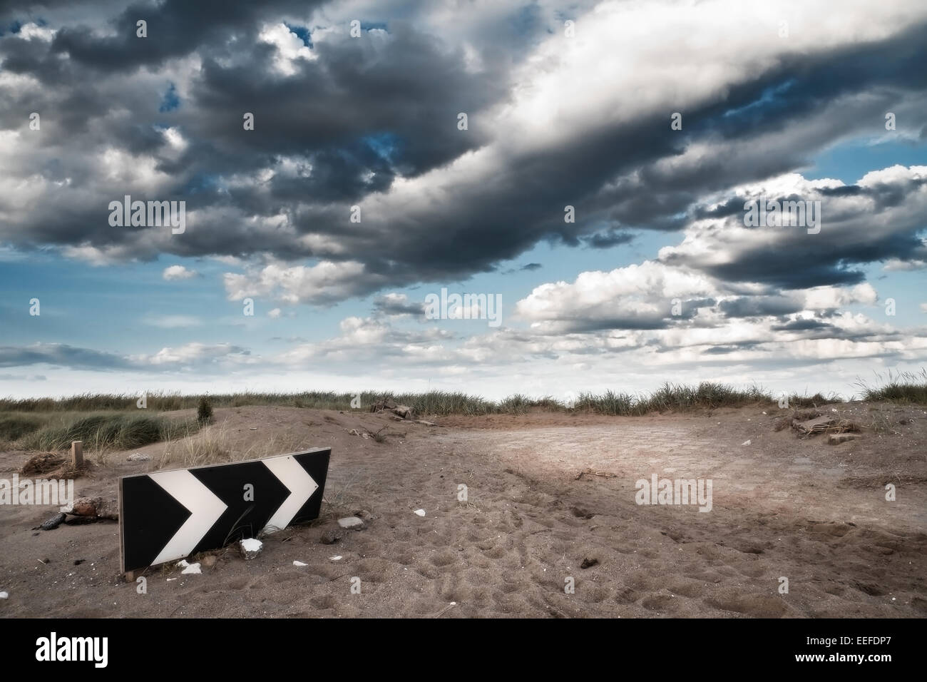 Photographie prise à rejeter Point, montrant un panneau routier en partie englouti par le sable de la plage. Banque D'Images