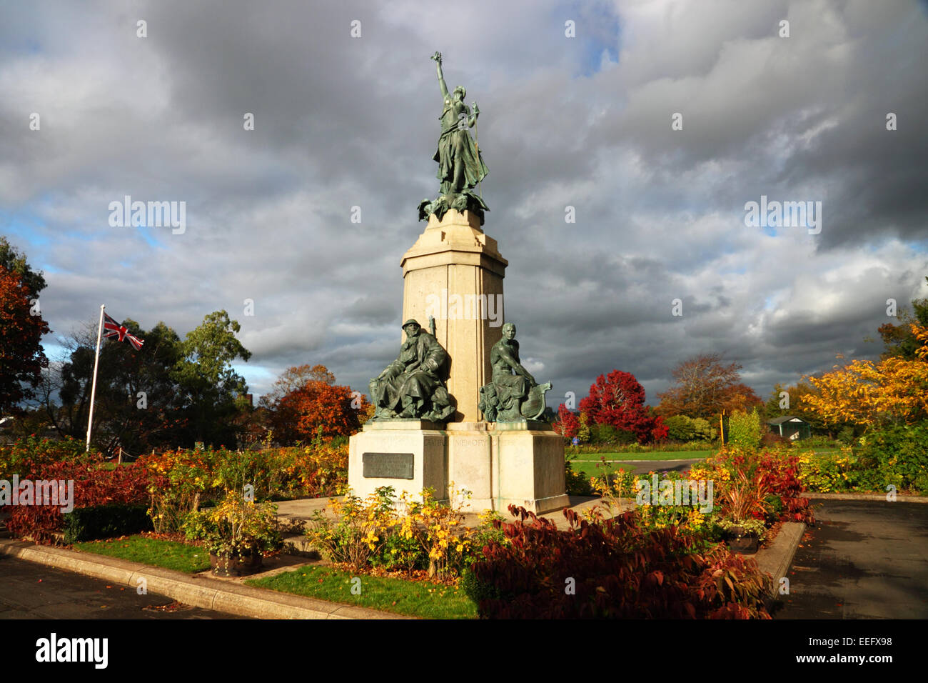 Un mémorial de guerre avec les figures en bronze et à l'automne feuillage, photographié en basse lumière. soir Banque D'Images
