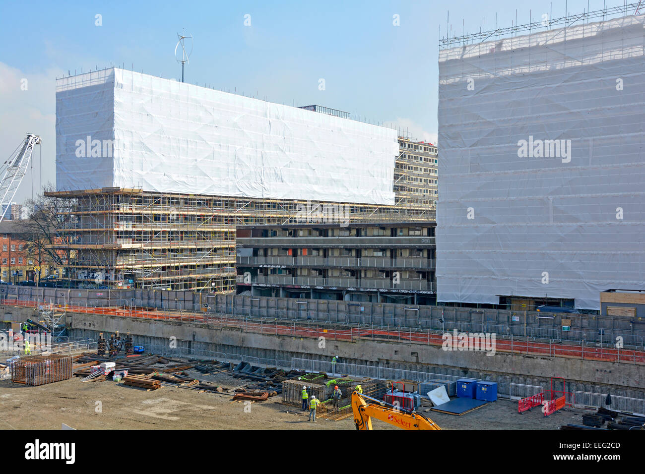 Offres et demandes de logement social dans le cocon de bâches en plastique et des échafaudages pour la sécurité pendant les travaux de démolition avec de nouveaux travaux de construction ont commencé le secteur dégagé UK Banque D'Images