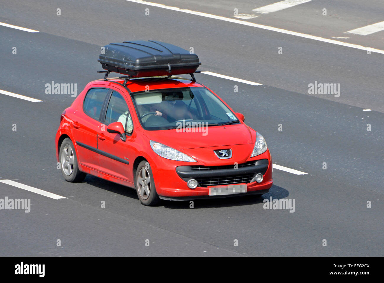 Conducteur de voiture Vauxhall rouge avec vue latérale avant, équipé d'un grand coffre à bagages de toit noir, longeant l'autoroute M25 Essex Angleterre Royaume-Uni Banque D'Images