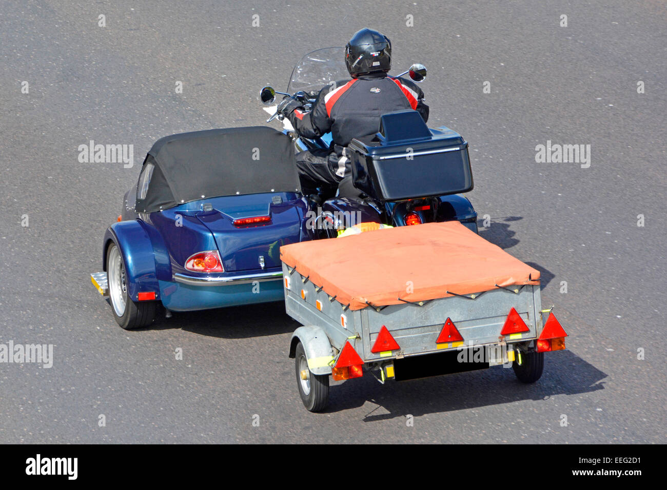 Pilote moto avec side-car tractant une petite remorque sur autoroute britannique obscurci numériquement autoroute M25 Plaque d'Essex England UK Banque D'Images