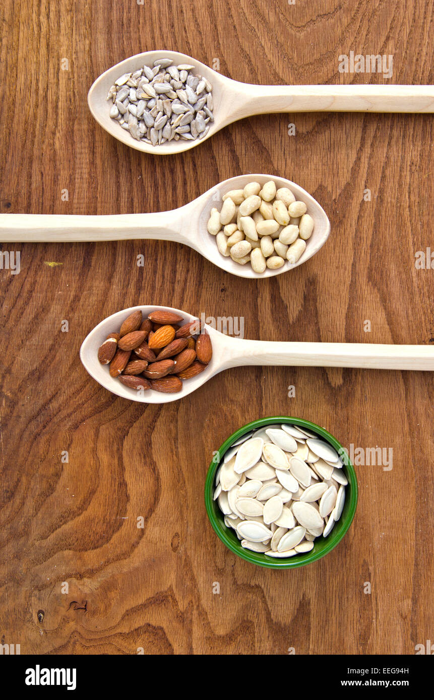 Cuillères en bois avec différents types de graines et d'écrous. Le régime alimentaire et la nutrition saine notion Banque D'Images