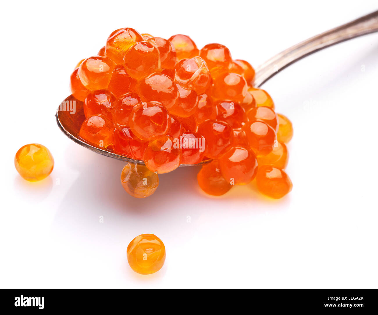 Caviar rouge dans la cuillère en argent isolé sur un fond blanc. Banque D'Images