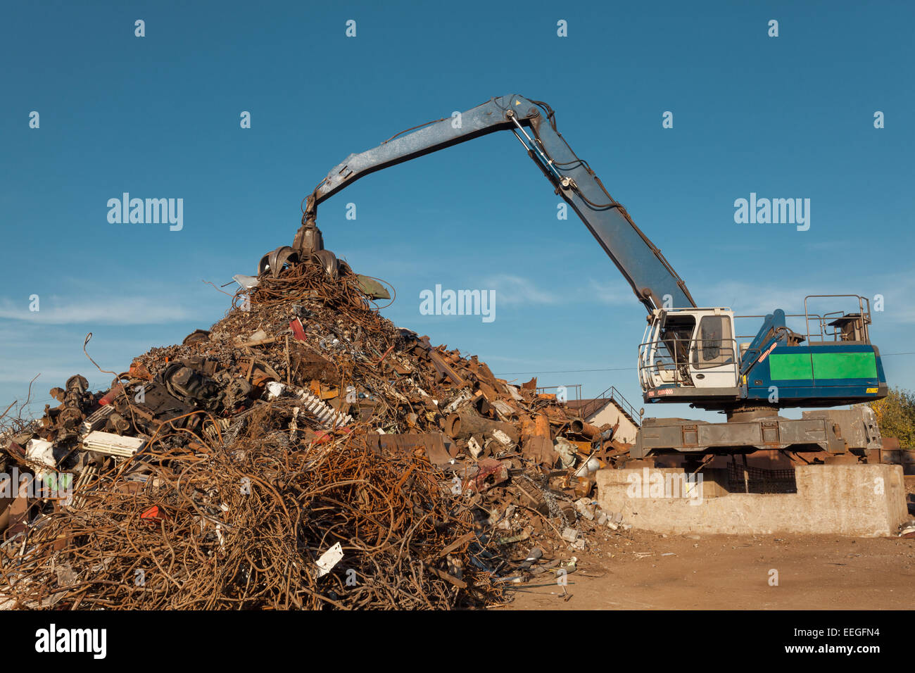 Tas de fer rouillé et la grue dans le recyclage des ferrailles Banque D'Images