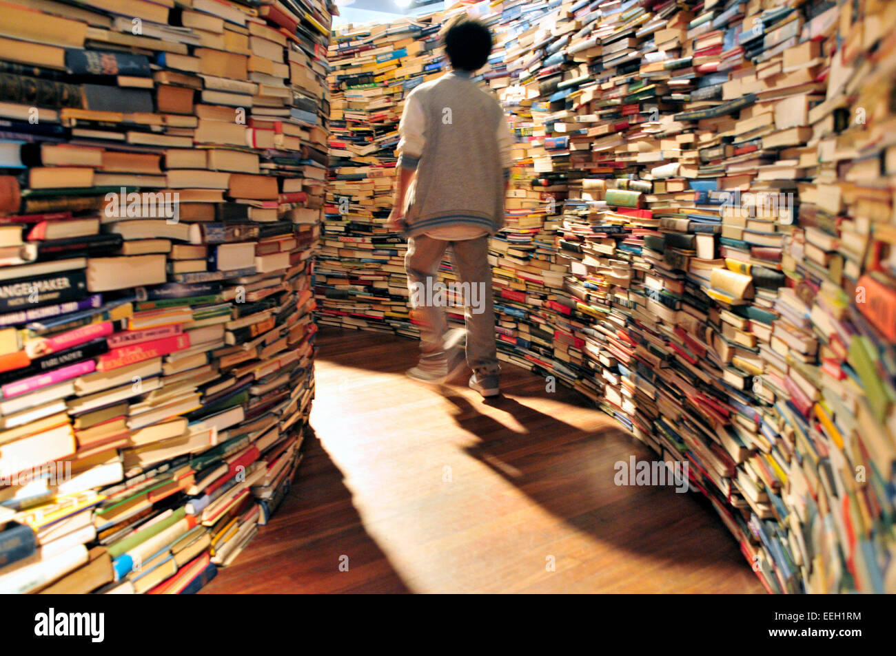 Un jeune garçon marche entre des piles de livres, une installation artistique appelé 'un labyrinthe me', Royal Festival Hall, London, UK Banque D'Images